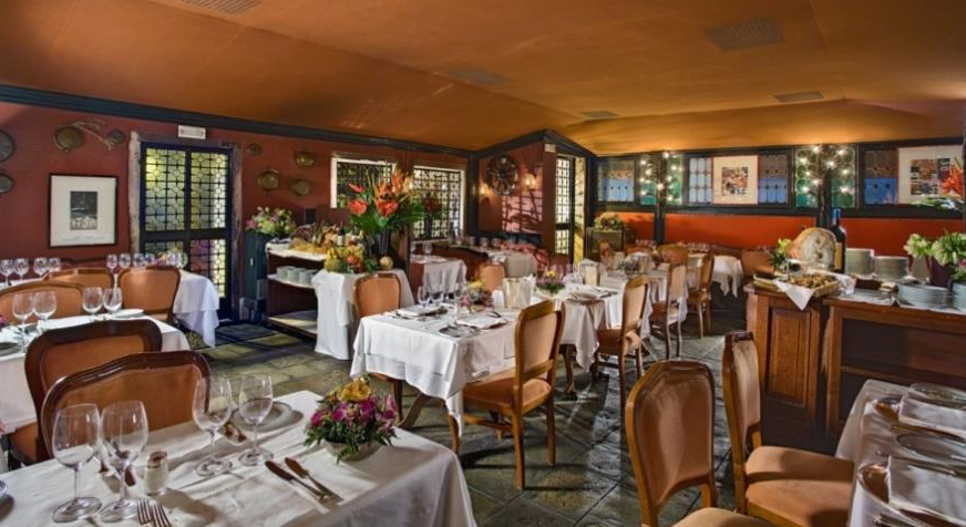 Innenansicht des Restaurants im Montecarlo Hotel mit gedeckten Tischen und Stühlen.