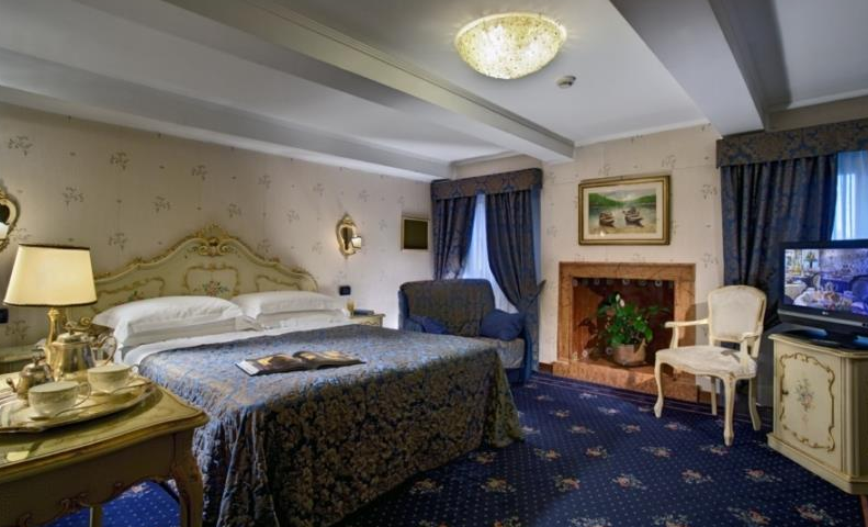 Hotelzimmer im Montecarlo mit Bett, Fernseher, Kamin und Möbeln.
