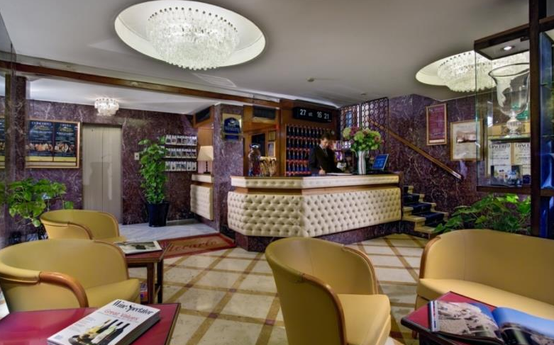 Lobby des Montecarlo Hotels mit Rezeption, Sesseln und Pflanzen.