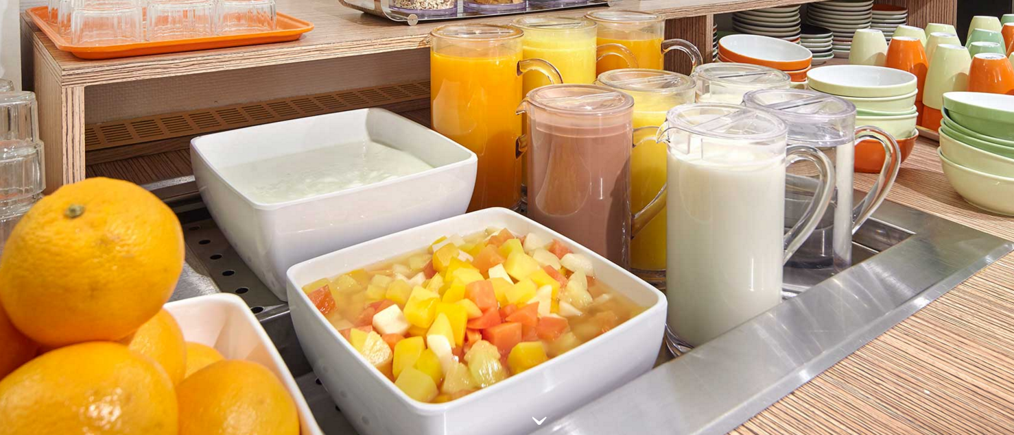 Frühstücksbuffet im Nova Hotel mit verschiedenen Getränken und Früchten.