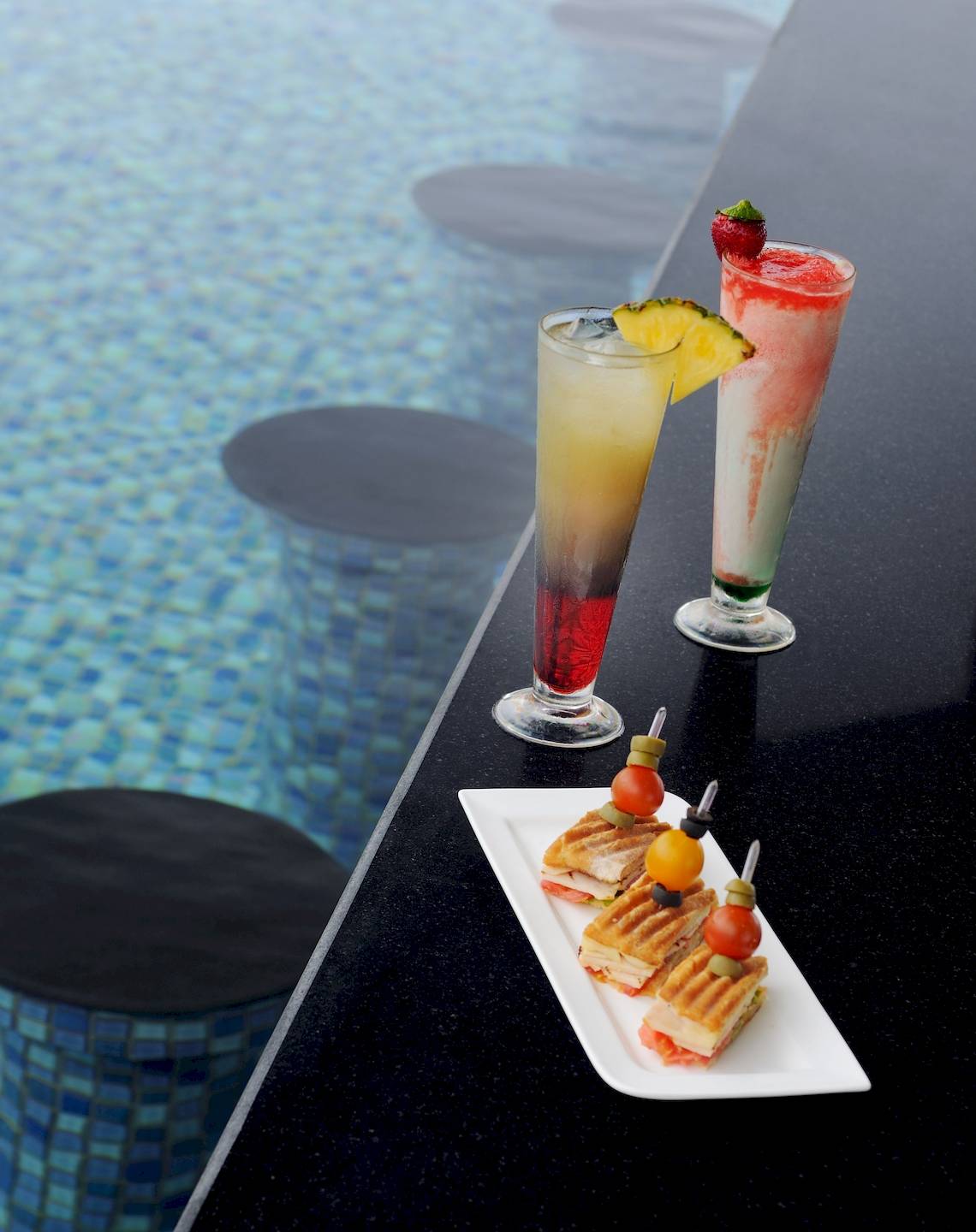 Drei Getränke und Sandwiches am Poolrand des Wyndham Garden Salalah Mirbat