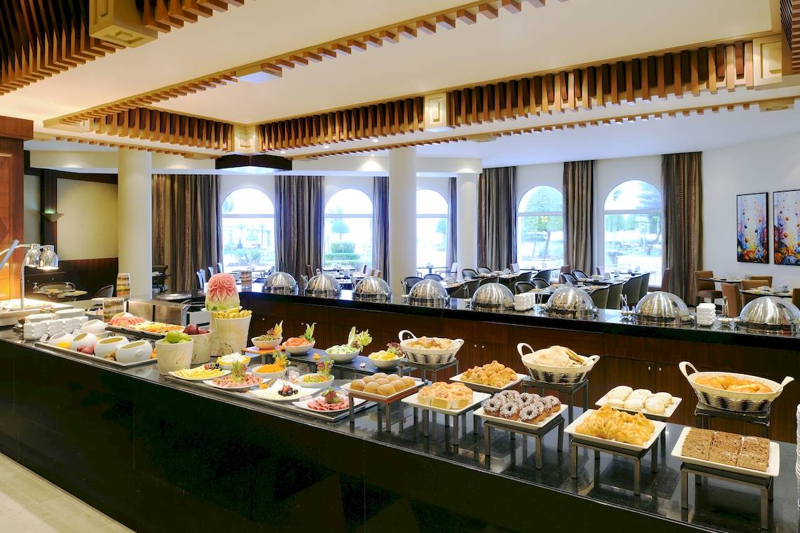 Buffet-Tisch im Wyndham Garden Salalah Mirbat Hotel mit verschiedenen Gerichten und Desserts.