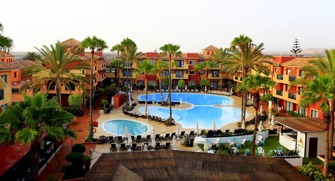 Ein Hotelkomplex mit mehreren Swimmingpools, Liegestühlen und Palmen, das BLUESEA Aloe Corralejo.