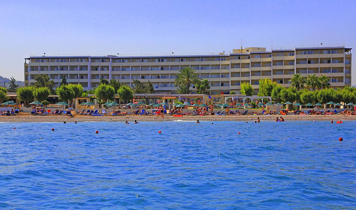 Blue Bay Beach Resort am Strand mit vielen Gästen und Palmen im Hintergrund