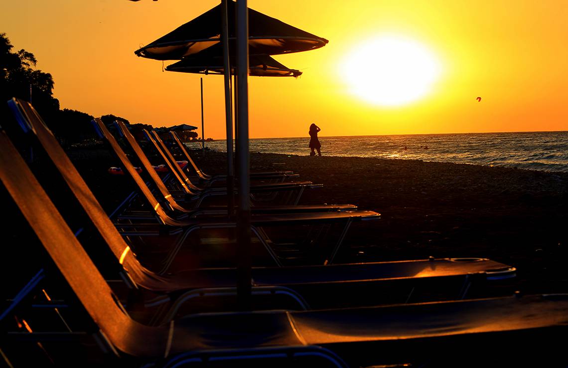 Sonnenuntergang am Strand des Blue Bay Beach Resorts mit einer Person im Vordergrund.