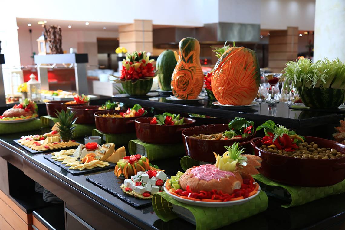 Buffet-Tisch im Blue Bay Beach Resort mit verschiedenen Gerichten und dekorativen Kürbissen.