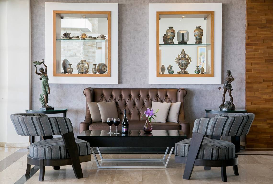 Lobby-Lounge des Asterias Beach Hotels mit Möbeln, Vasen und Statuen.