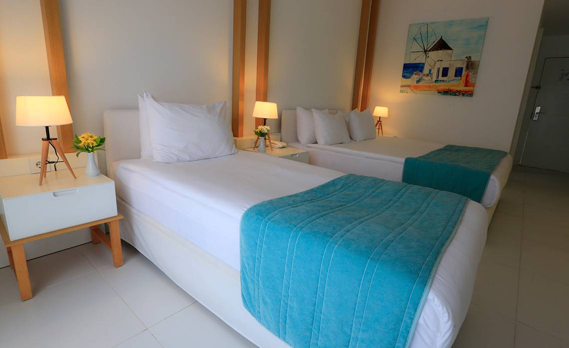 Doppelzimmer im LABRANDA TMT Bodrum mit zwei Betten, weißer Bettwäsche und blauen Decken.