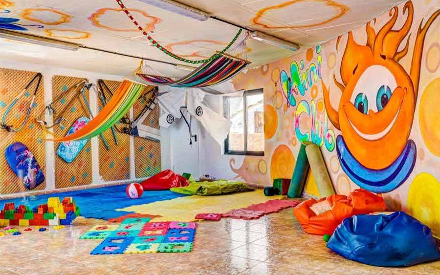 Kinderspielzimmer im SBH Club Paraiso Playa mit bunten Wandmalereien, Hängematten und Spielzeug.