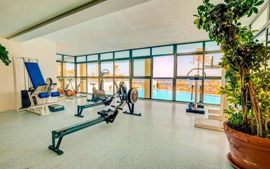 Fitnessstudio im SBH Club Paraiso Playa mit Blick auf den Pool.