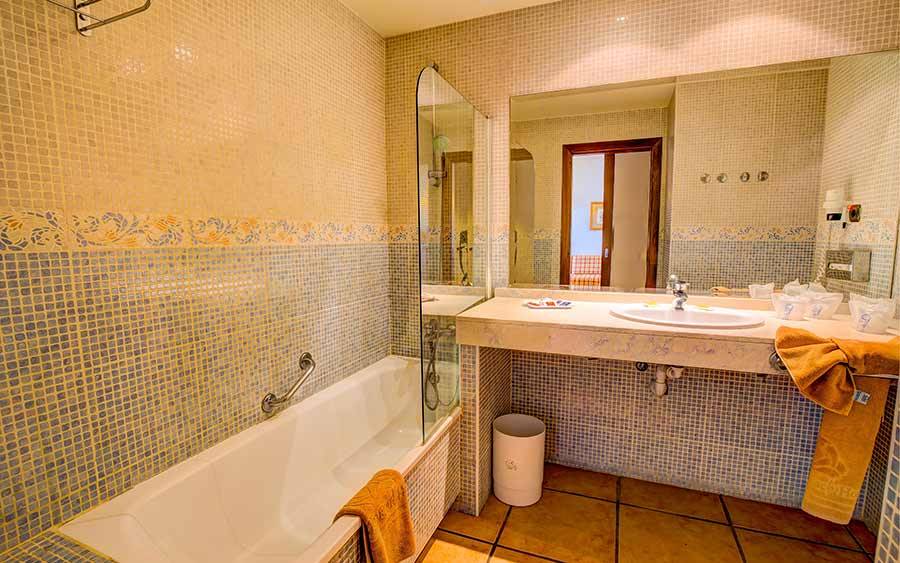 Badezimmer im SBH Club Paraiso Playa Hotel mit Badewanne, Spiegel und Waschbecken.