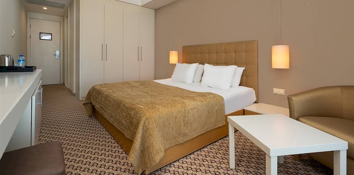 Doppelzimmer im Crystal Centro Resort Hotel mit Bett, Tisch und Sitzbereich.