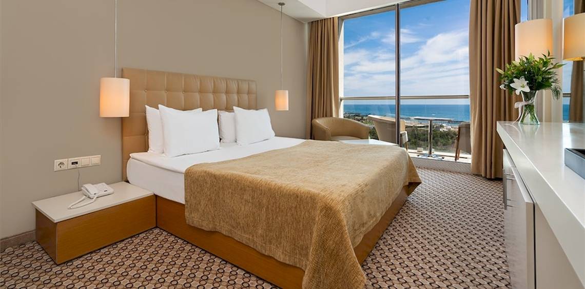 Hotelzimmer im Crystal Centro Resort mit Meerblick, inklusive Bett, Fenster und Balkon.