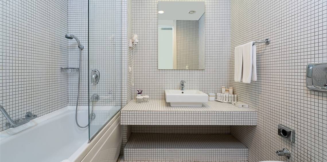 Badezimmer im Crystal Centro Resort mit Badewanne, Dusche, Spiegel und Waschbecken.