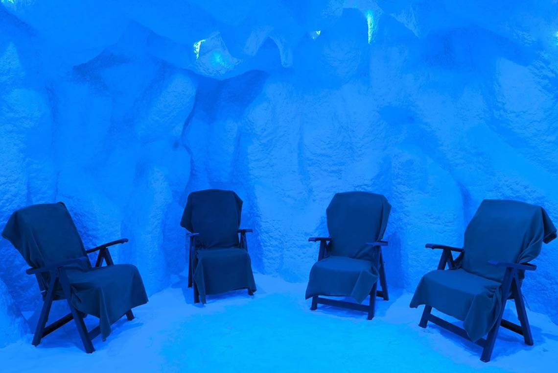 Vier Stühle in einem blauen Behandlungsraum des Delphin Imperial Hotels