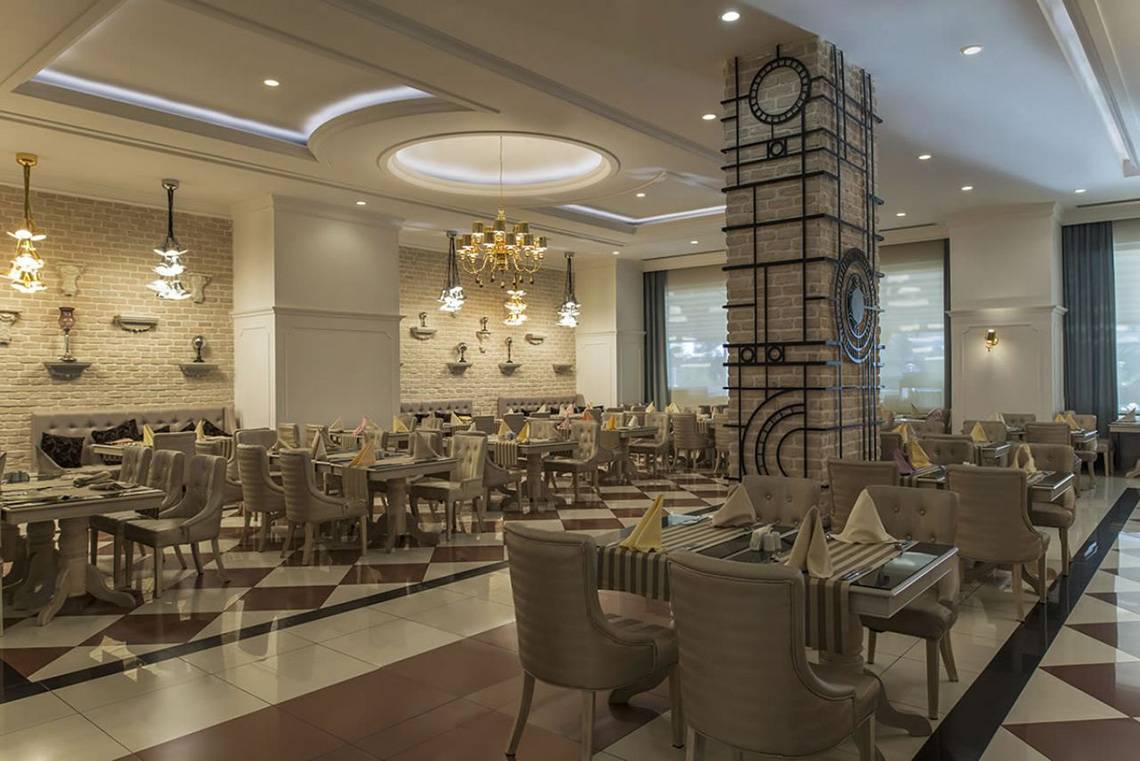 Restaurant des Delphin Imperial Hotels mit braun-weißem Schachbrettboden und braunen Stühlen.