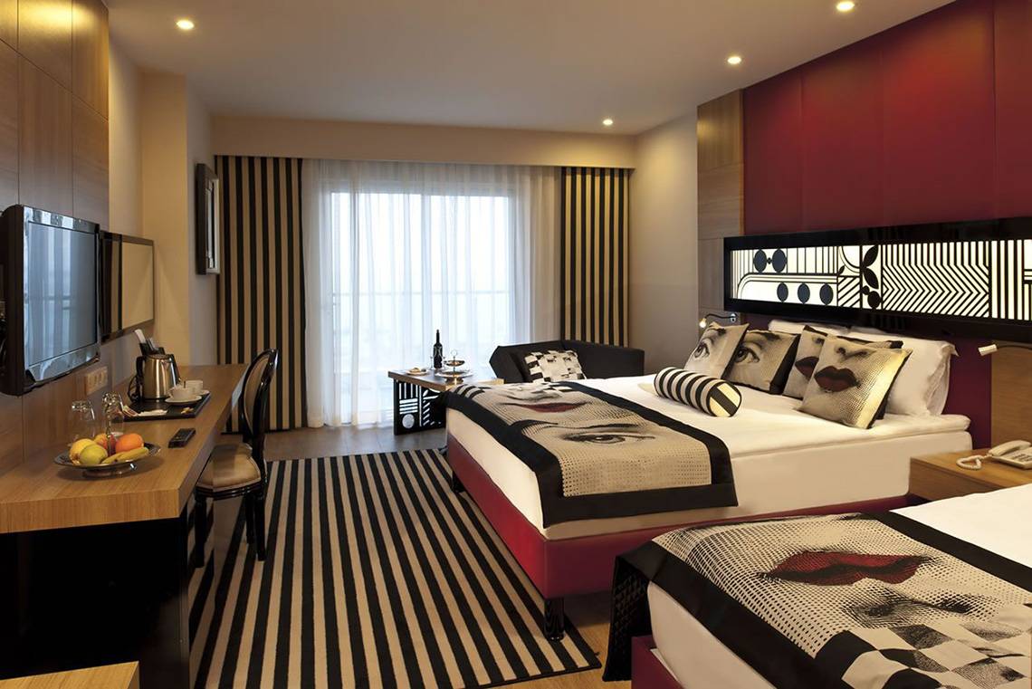 Doppelbett-Zimmer im Delphin Imperial Hotel mit zwei Betten, Dekor, Fenster und Fernseher.