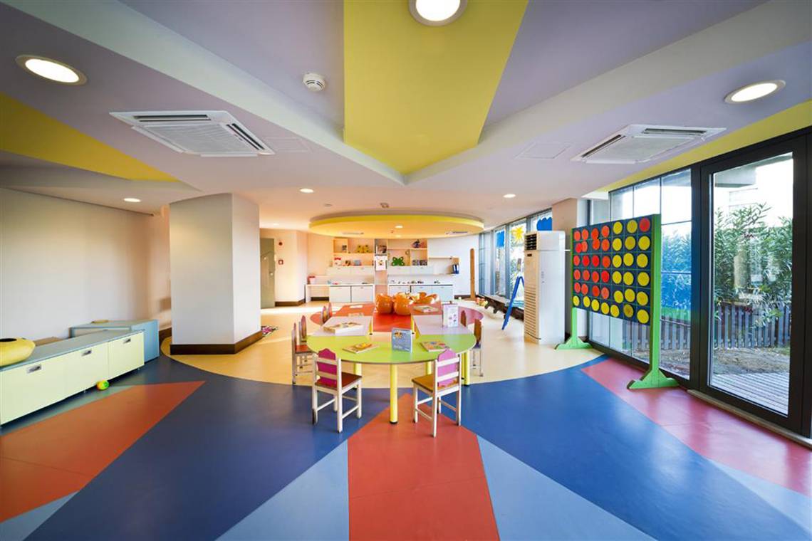 Kinderspielbereich im Limak Lara De Luxe Hotel & Resort mit bunten Böden und Möbeln.