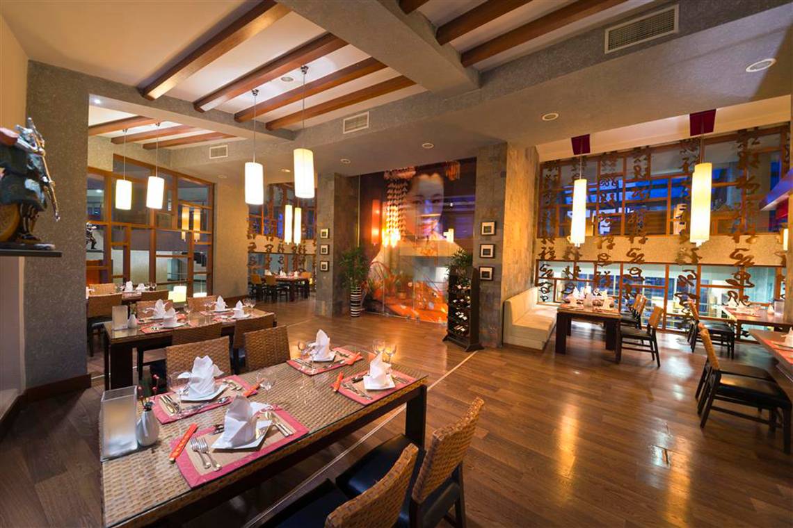 Innenansicht des Restaurants im Limak Lara De Luxe Hotel & Resort mit Holzboden und gedeckten Tischen.