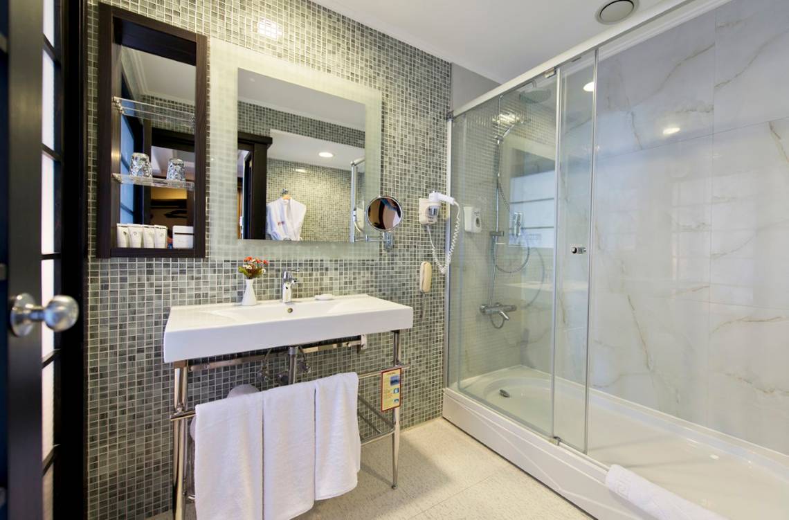 Badezimmer im Limak Lara De Luxe Hotel mit Dusche und Waschbecken.