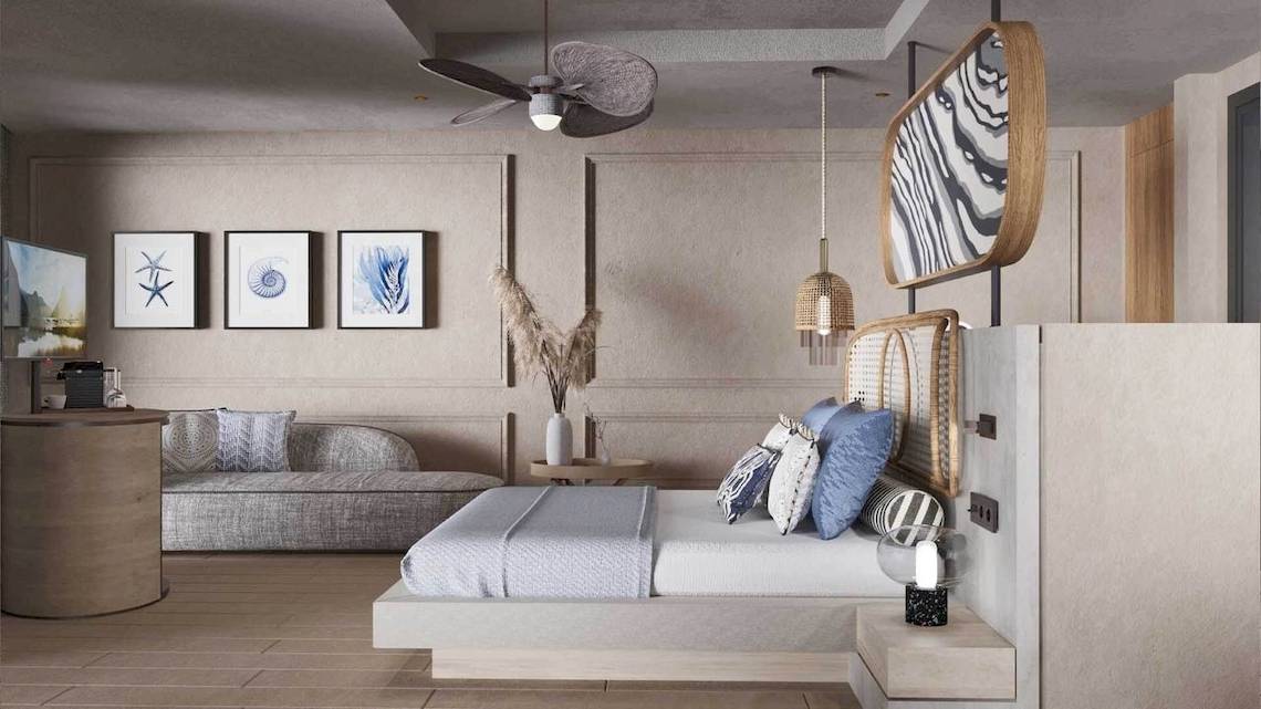 Innenansicht eines Schlafzimmers im Liu Resorts mit Bett, Couch, Tisch und Kunstwerken an der Wand.
