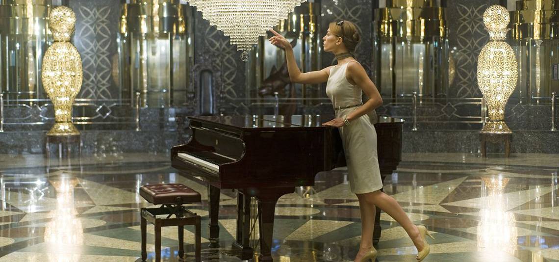 Eine Frau im Delphin Palace Hotel führt ein Klavier in einem luxuriösen Raum.