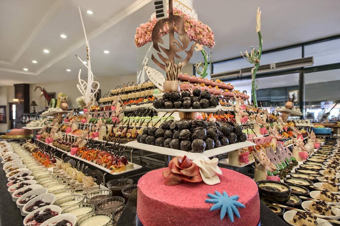 Buffetauswahl im Delphin Palace Hotel mit einer Vielzahl von Desserts und Kuchen.