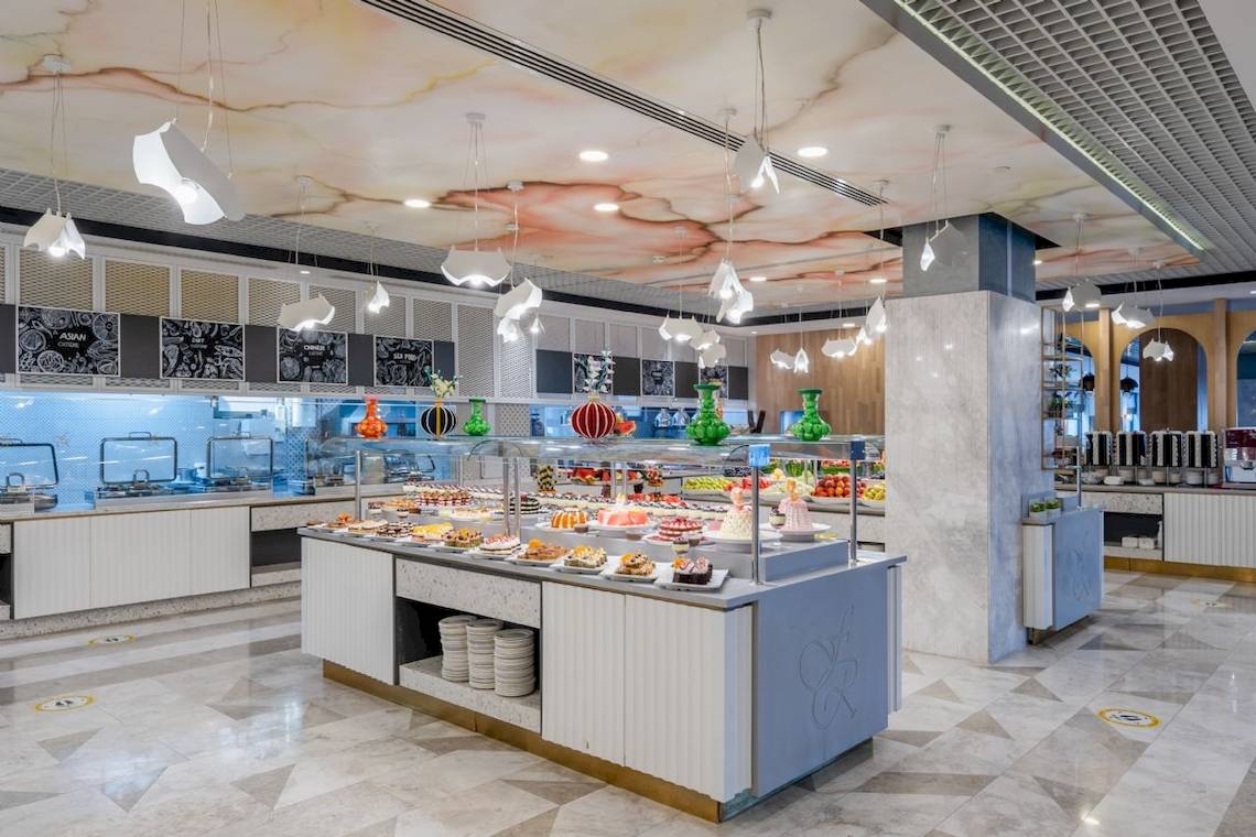 Buffet-Tisch im Fame Residence Kemer & Spa Hotelrestaurant mit verschiedenen Speisen und Kuchen.