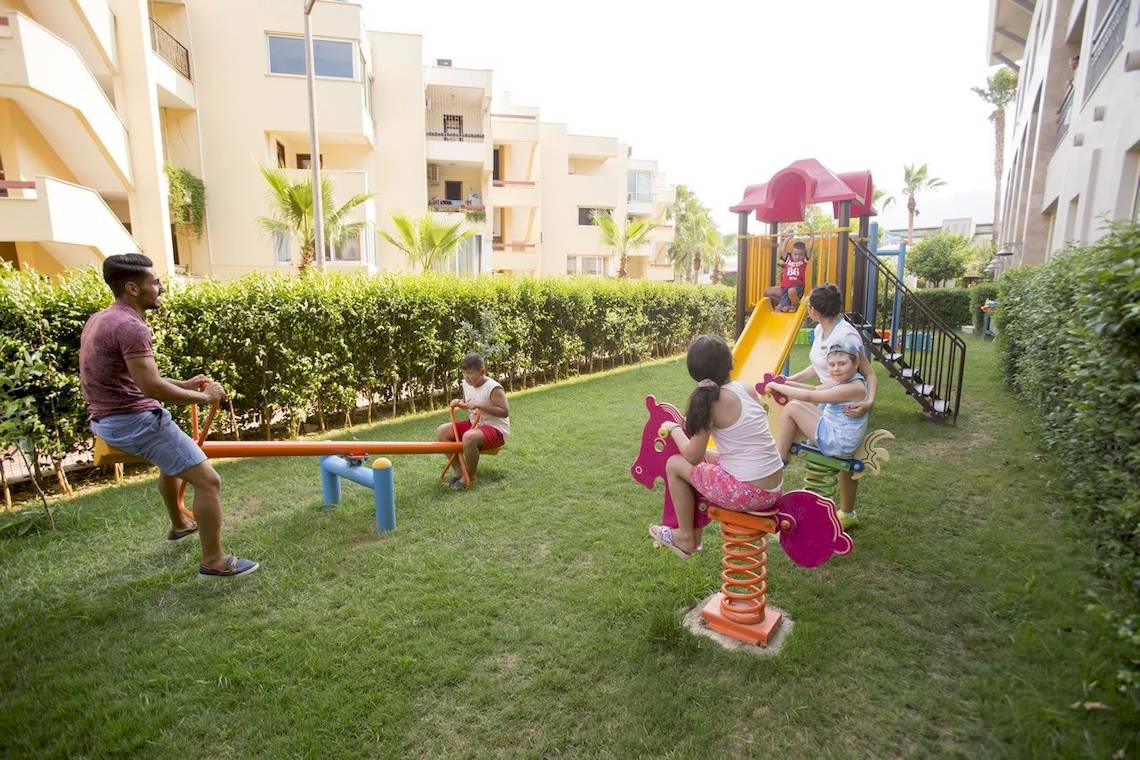 Kinder spielen auf einem Spielplatz im Fame Residence Kemer & Spa Hotel.