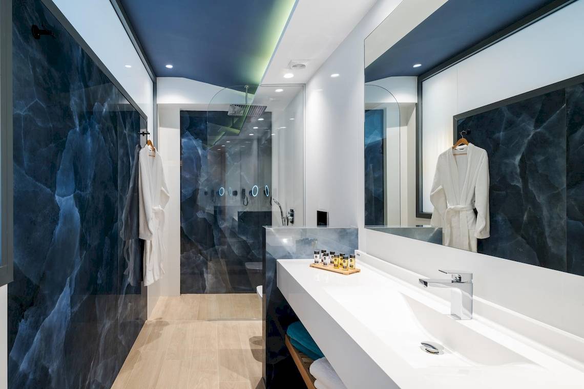 Badezimmer im Lyttos Mare Hotel mit blauen Wänden und moderner Einrichtung.
