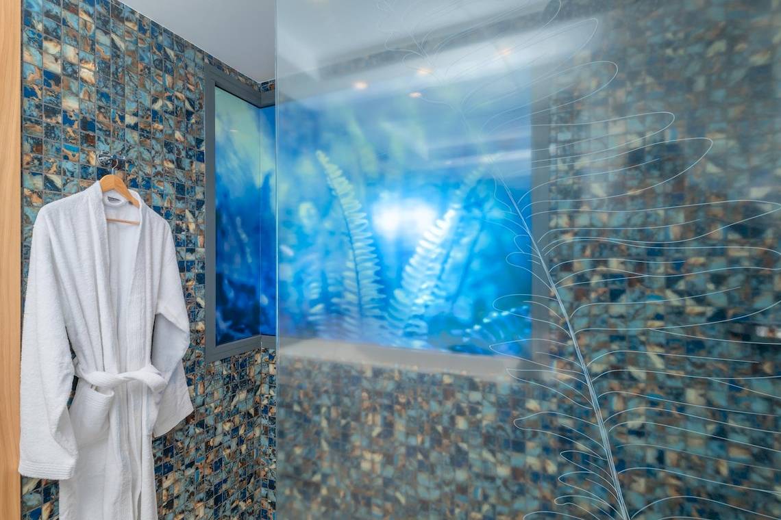 Ein weißer Bademantel hängt an einer Wand im Lyttos Mare Hotel.