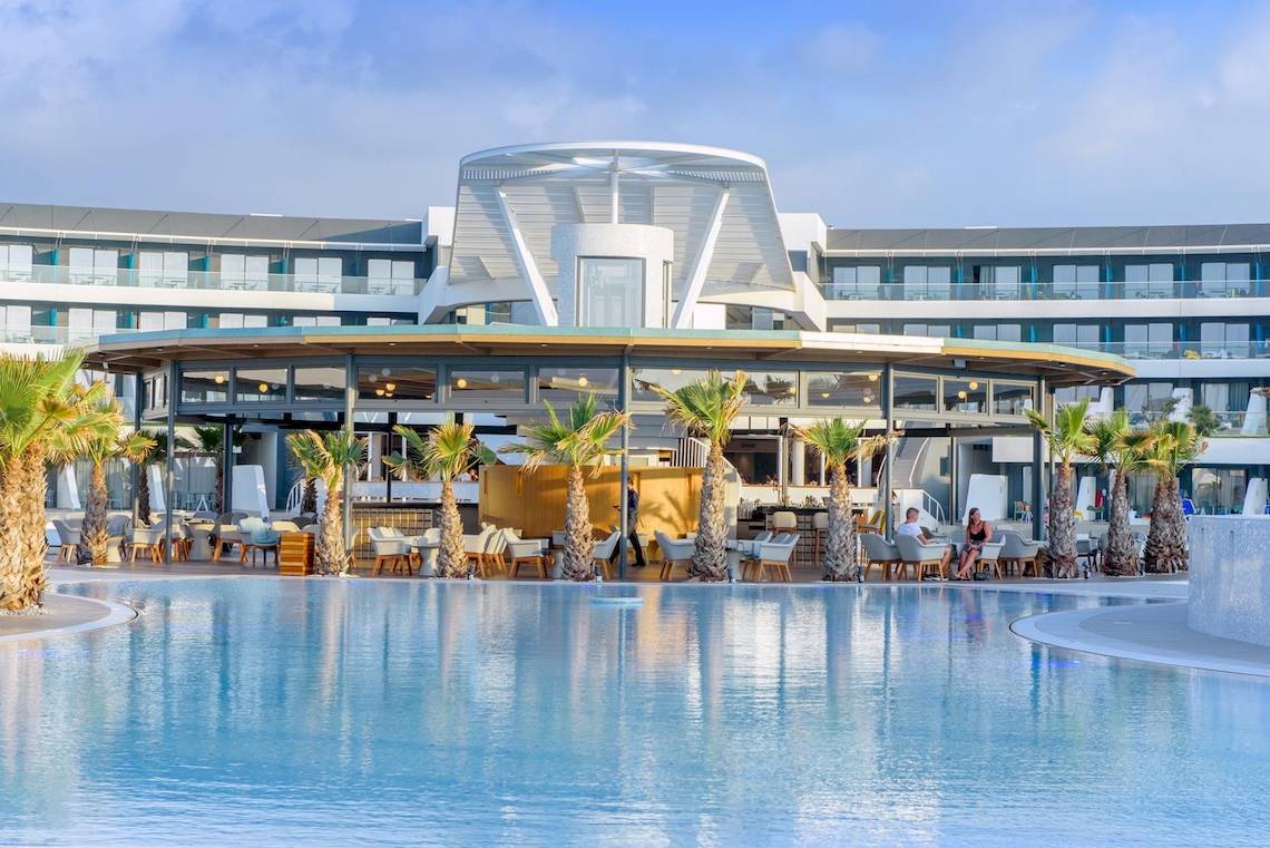 Poolbereich des Lyttos Mare Hotels mit moderner Architektur und Palmen