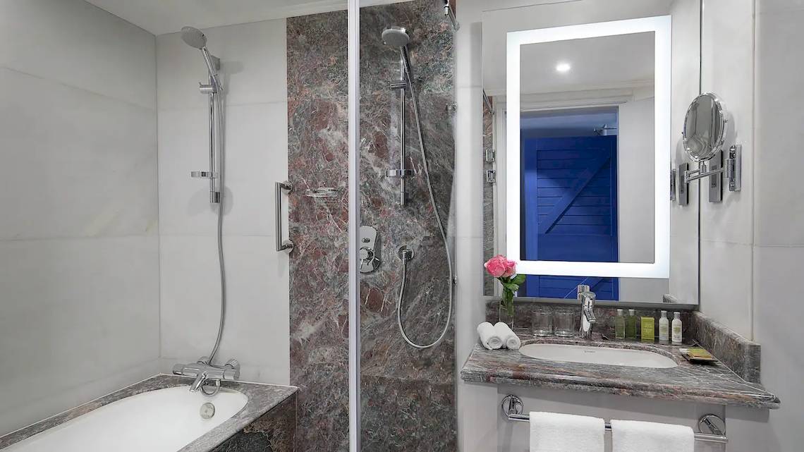 Badezimmer im Hilton Hurghada Plaza Hotel mit Badewanne, Dusche, Spiegel und Waschbecken.