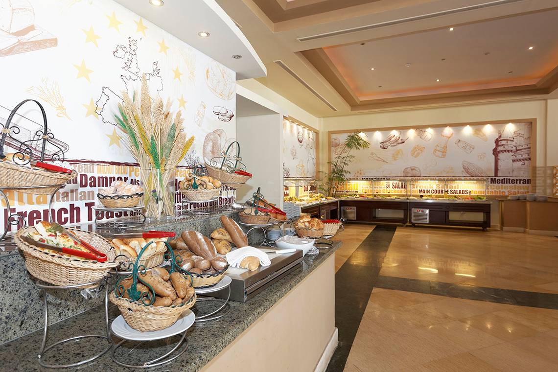 Frühstücksbuffet im Three Corners Sea Beach Resort mit verschiedenen Brotsorten und Körben.