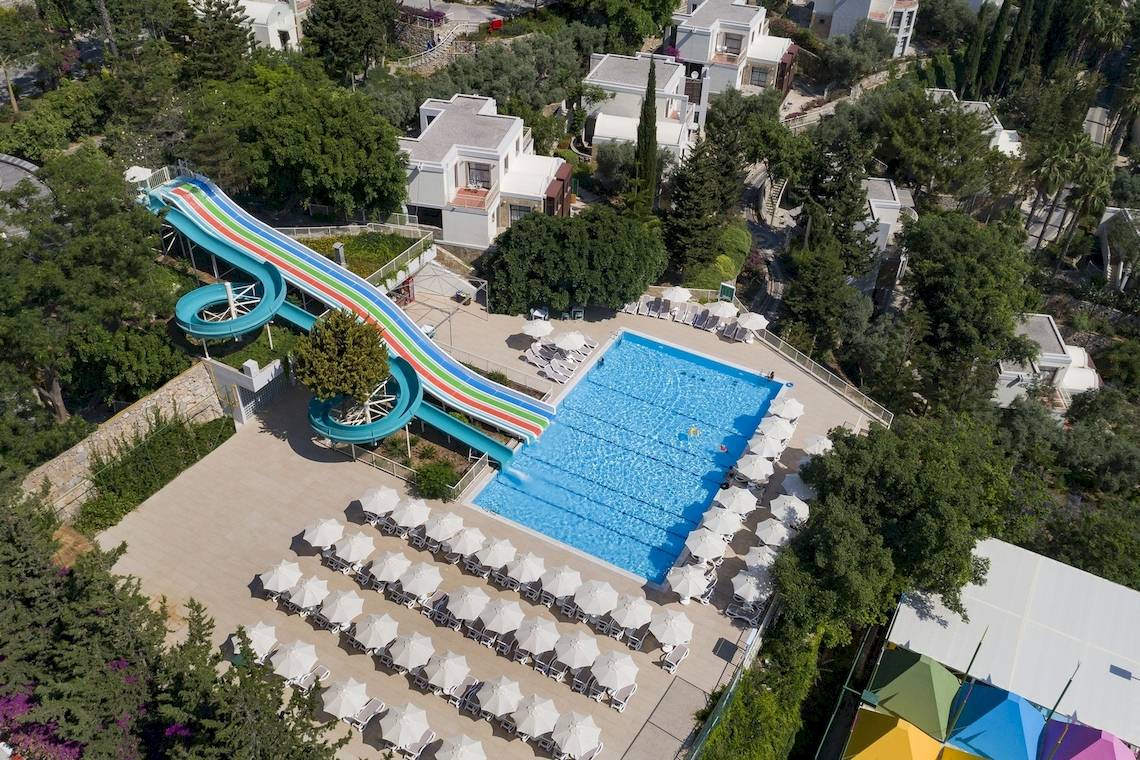 Oberflächenansicht des Duja Bodrum Hotels mit Swimmingpool und Wasserrutsche.