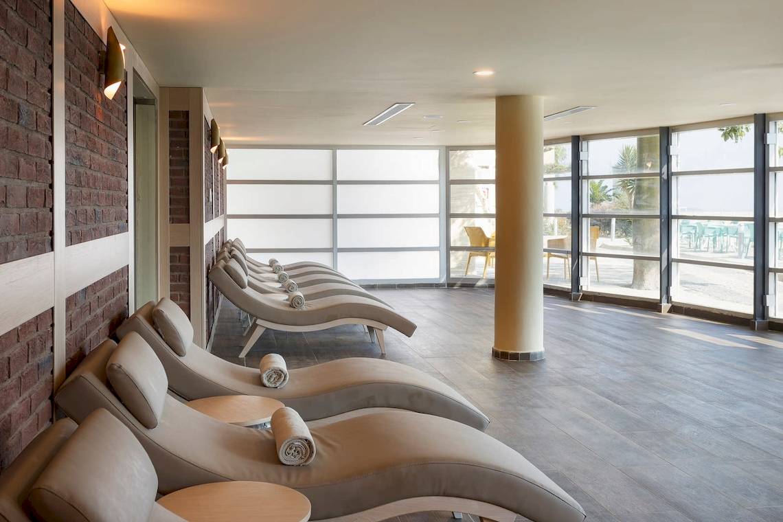 Innenansicht des Entspannungsbereichs des Duja Bodrum Hotels mit mehreren Liegen und Glaswänden.