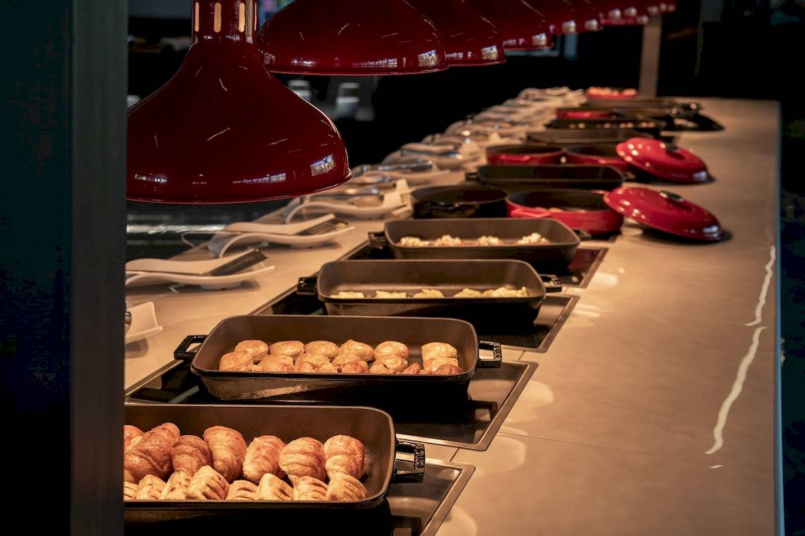Buffet-Tisch im CHC Galini Palace mit verschiedenen Gerichten und roten Lampen.