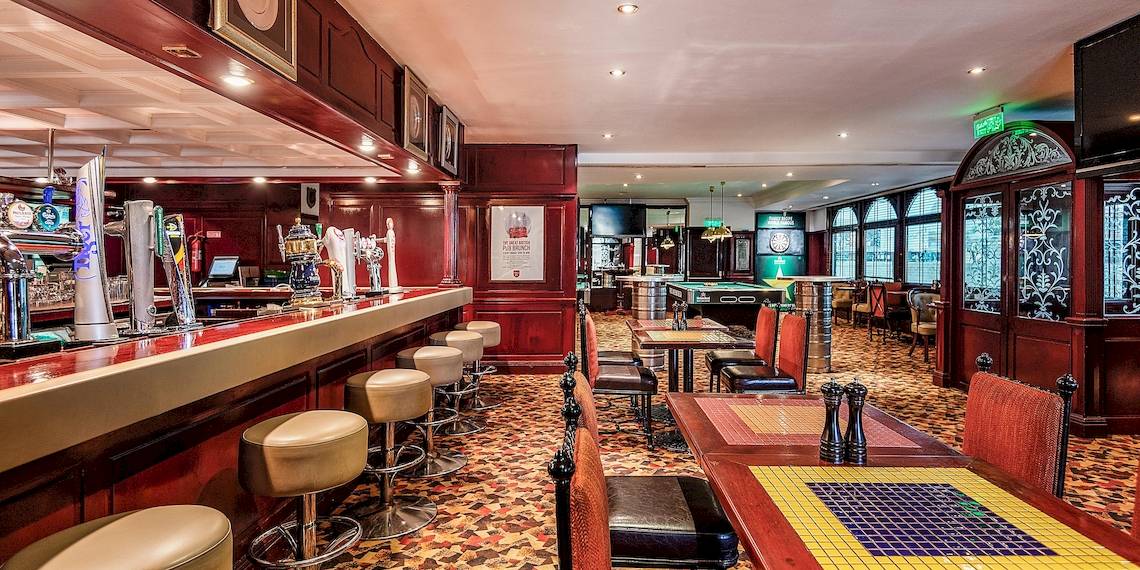 Innenansicht des Hotel-Loungs mit Bar, Tischen und Stühlen im InterContinental Muscat, an IHG Hotel