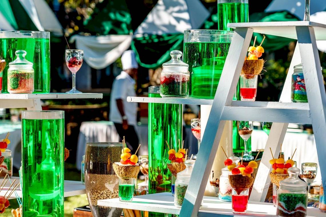 Cocktailstation im Baobab Beach Resort mit grünen Getränken in Flaschen und Gläsern.