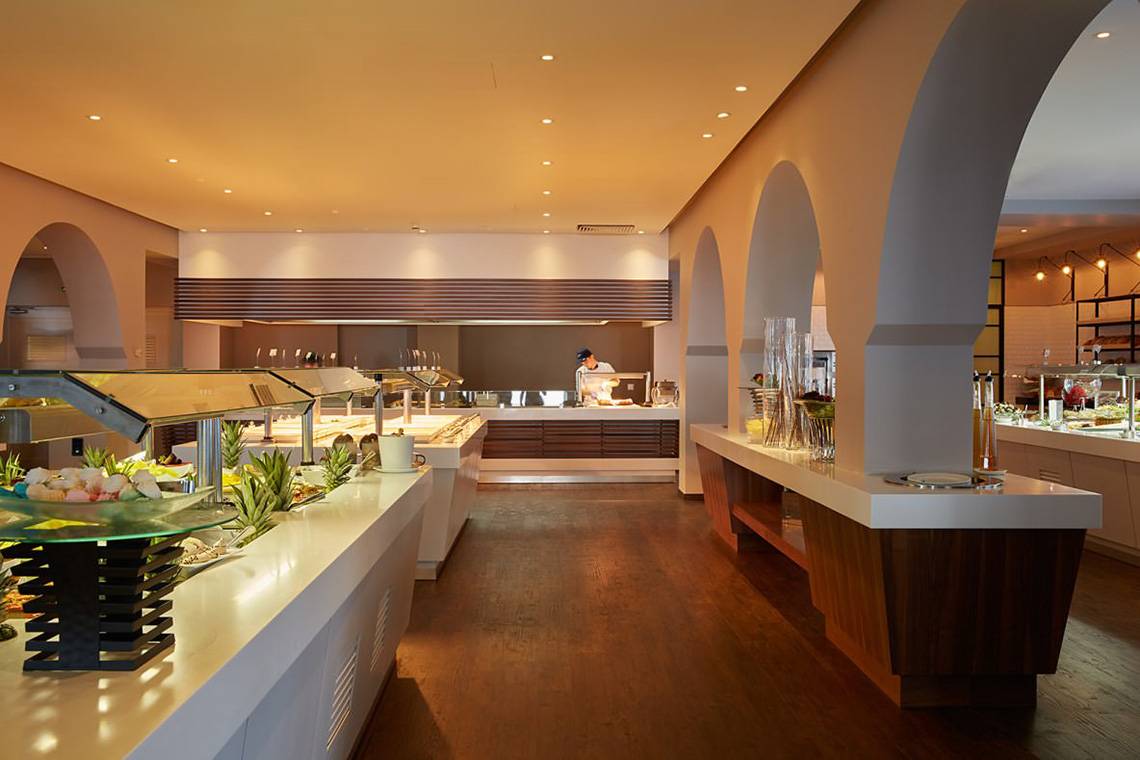 Das Innendesign des Speisesaals im MarBella Corfu Hotel mit Buffets und einem Angestellten.
