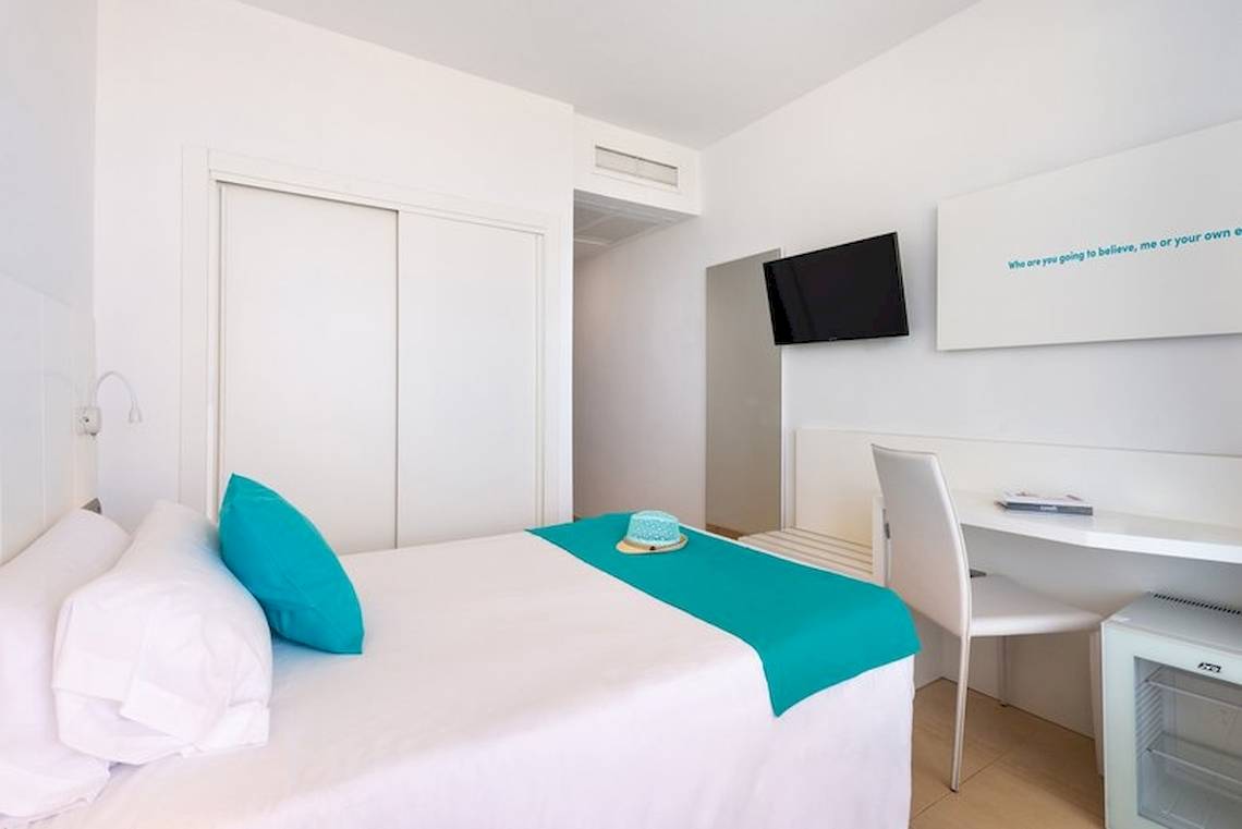 Innenansicht eines Zimmers im Vibra Algarb Hotel mit einem Bett, Schreibtisch und Fernseher.