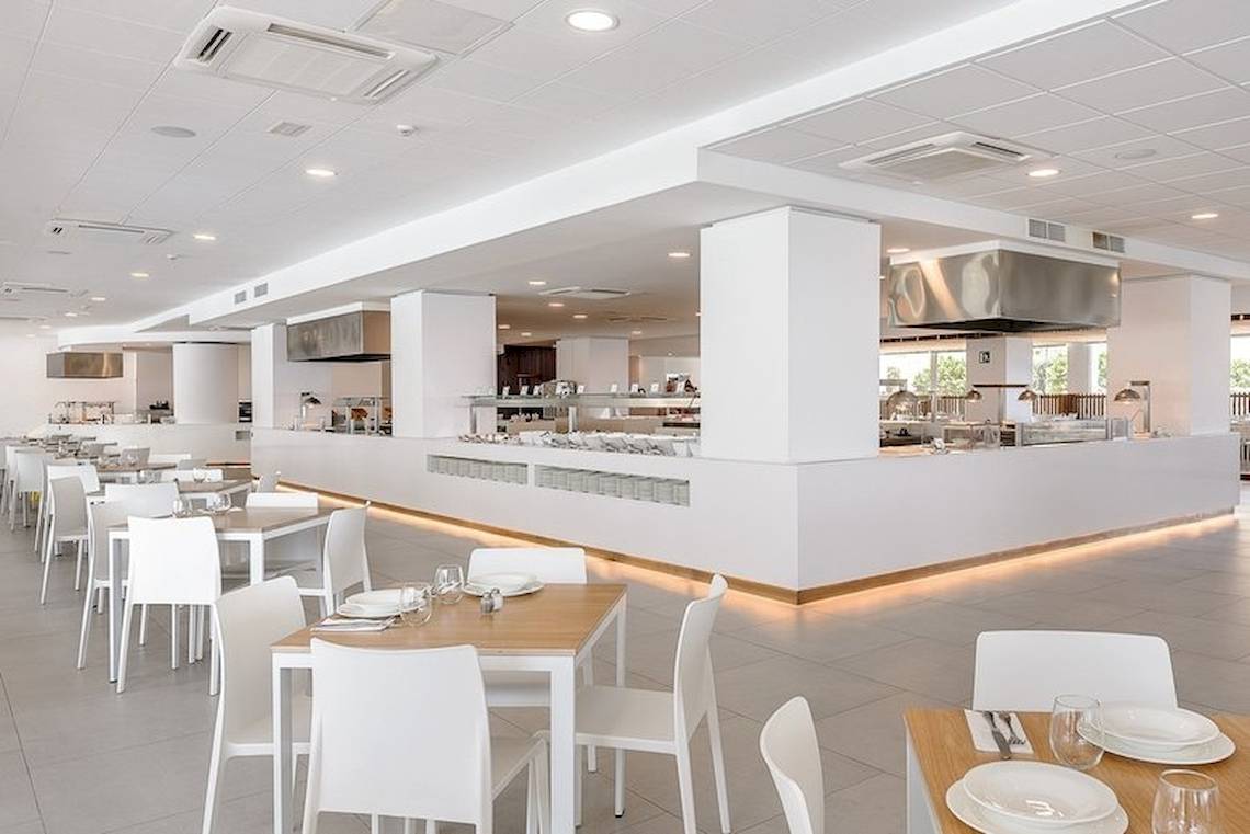 Innenansicht des Restaurants im Vibra Algarb Hotel mit weißen Tischen und Stühlen.