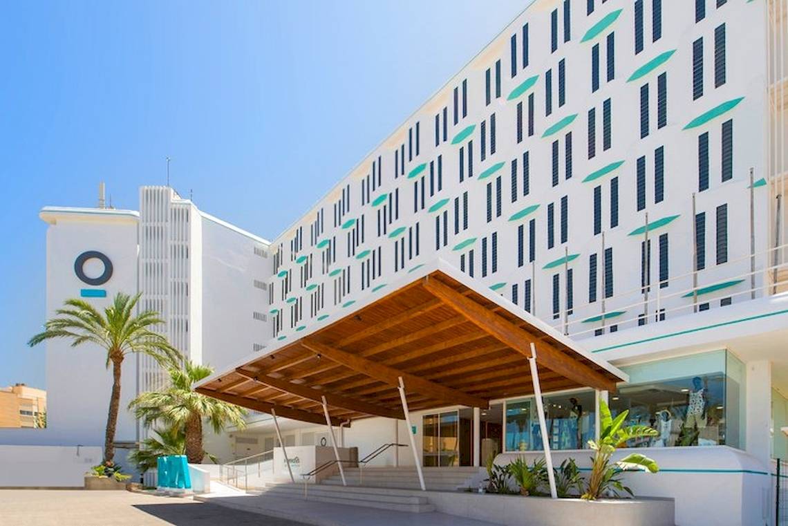 Außenansicht des Vibra Algarb Hotels mit geometrischen Mustern, Eingangsbereich und Palmen.