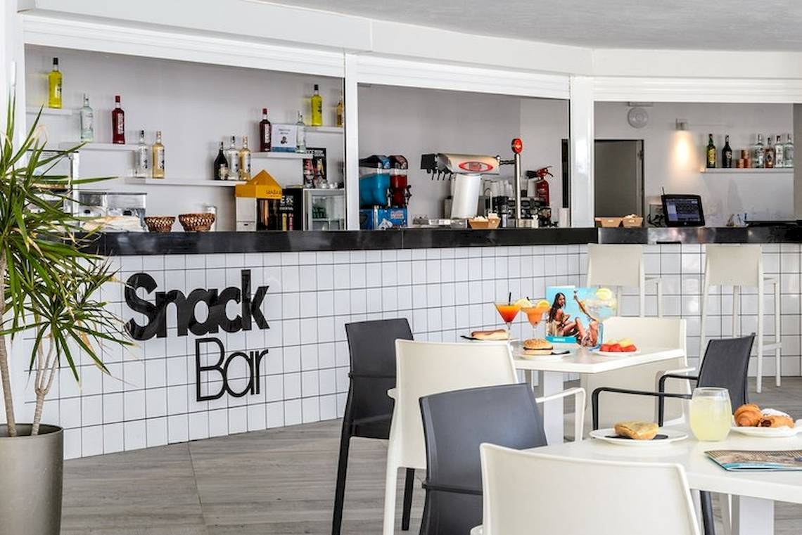 Innenansicht der Snack Bar im Vibra Algarb Hotel mit Bar, Tischen, Stühlen und Getränken.