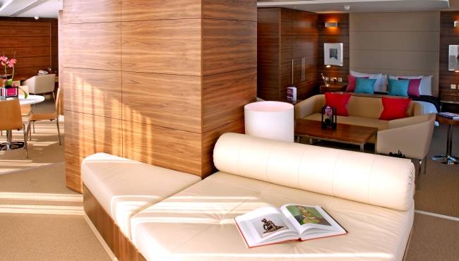 Innenansicht der Suite im Park Plaza County Hall London mit offenen Büchern auf einem weißen Sofa.