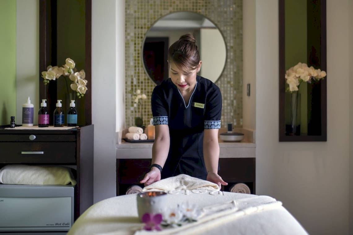 Eine Angestellte im Khalidiya Palace Rayhaan bereitet eine Massageliege vor.