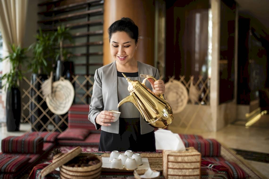 Mitarbeiterin im Khalidiya Palace Rayhaan Hotel bereitet Kaffee zu