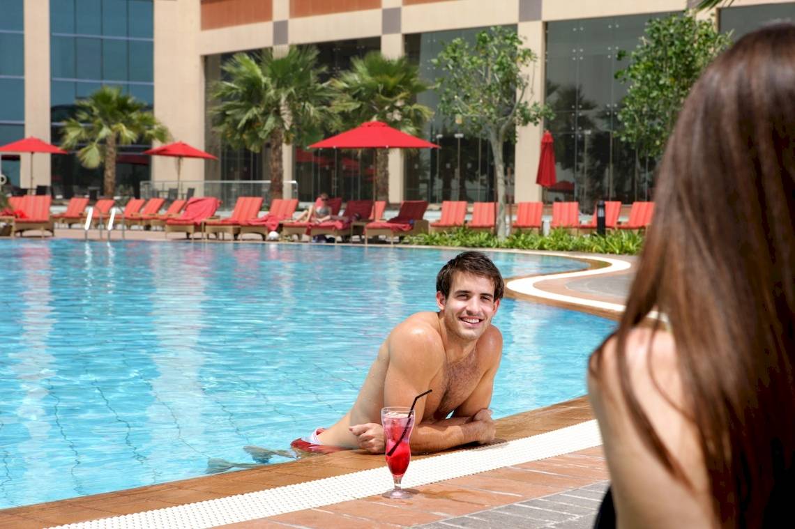 Mann im Pool vor dem Hotel Khalidiya Palace Rayhaan by Rotana