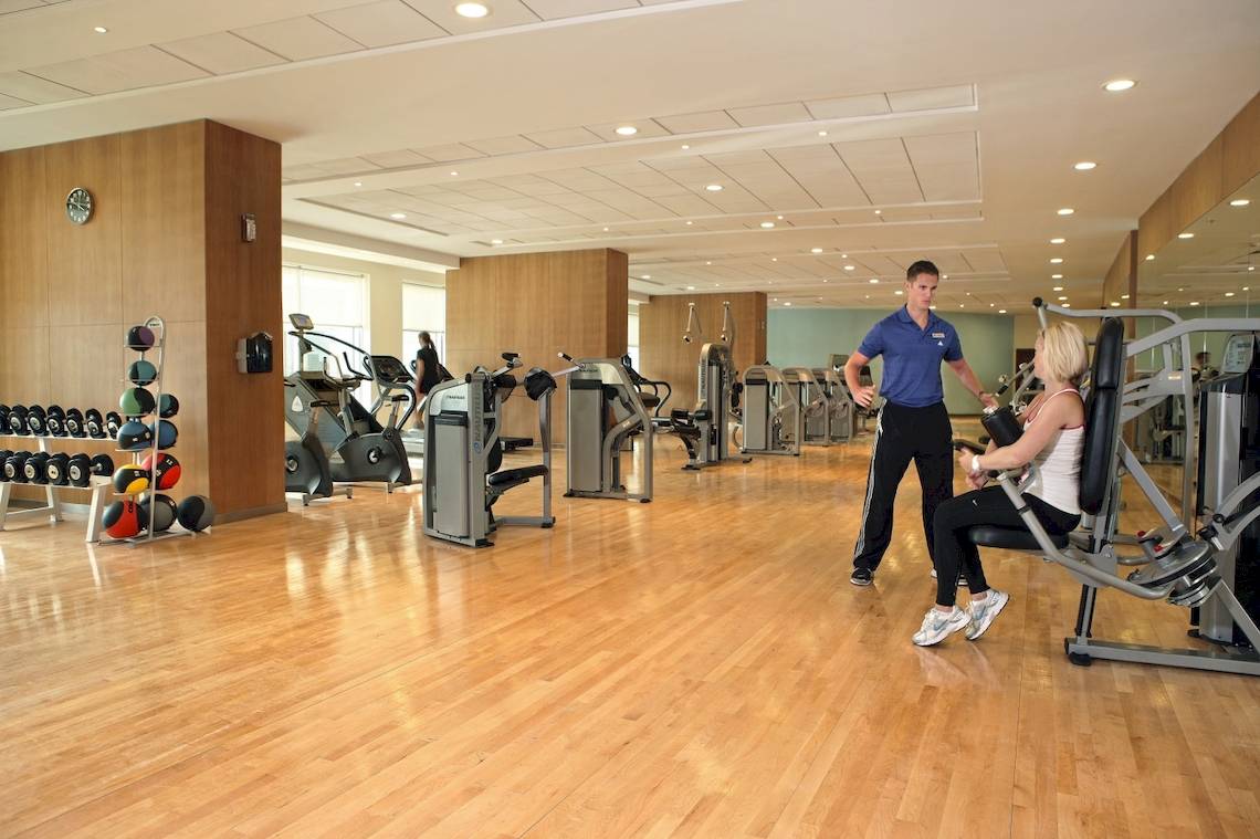 Fitnesscenter im Khalidiya Palace Rayhaan by Rotana Hotel mit gut ausgestatteten Geräten und Personal.