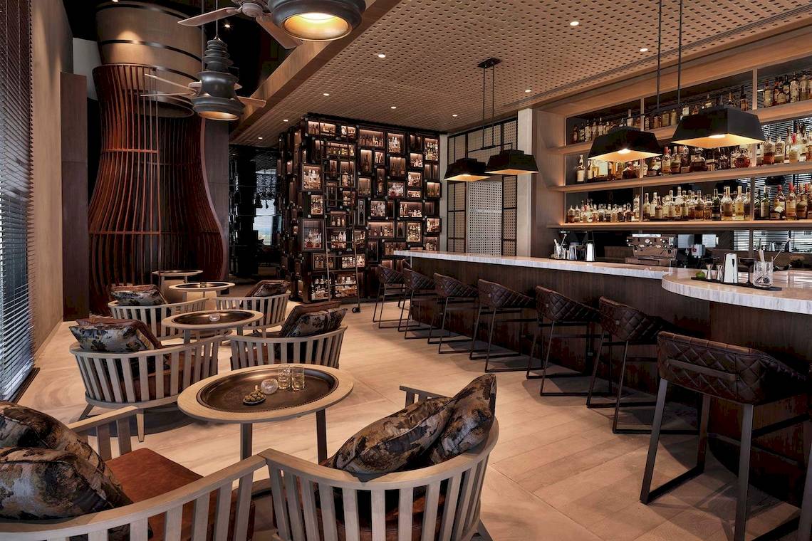 Innenansicht eines Hotel-Bars mit vielen Sitzgelegenheiten und einer Bartheken.